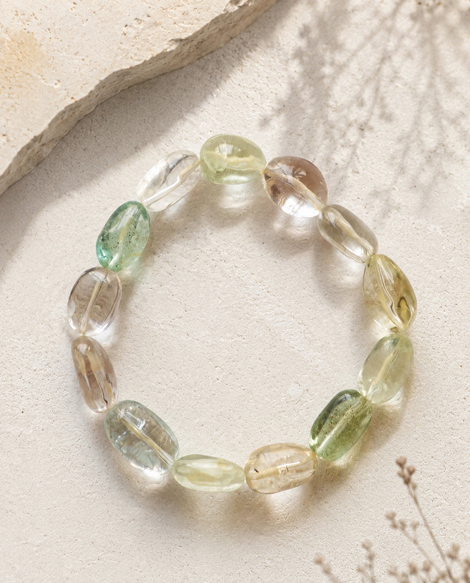 Natural multi-color beryl gemstone bracelet featuring high transparency morganite and heliodor, styled with soft botanical wabi-sabi shadows on textured stone.⁠