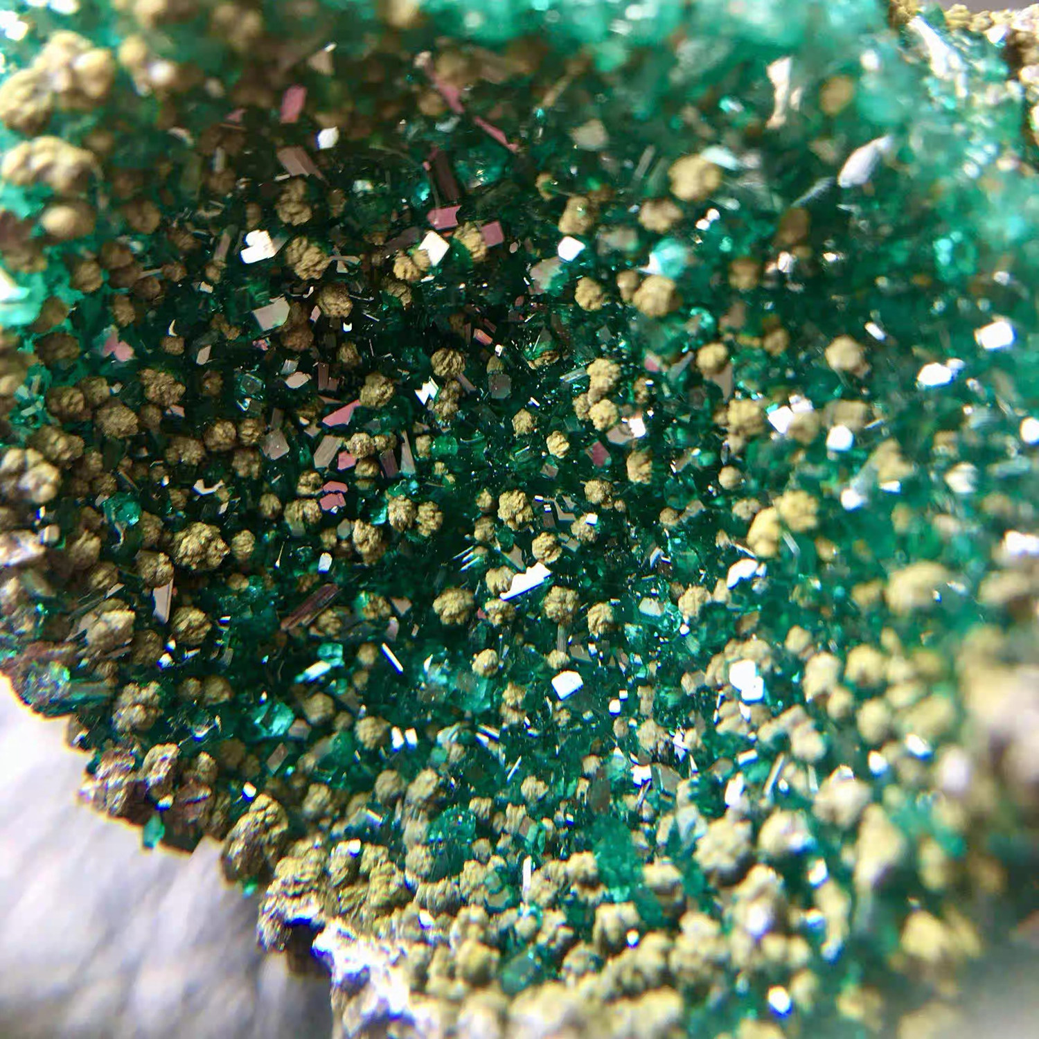 Extreme macro close-up of raw dioptase crystals showing vivid emerald green facets and natural matrix, unpolished earth art and healing mineral texture by STILLMANTLE