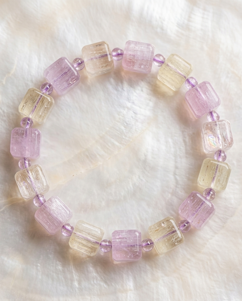 Top view of natural multi-color spodumene square crystal bracelet on a glowing shell surface, quiet luxury earth aesthetic wearable art by STILLMANTLE