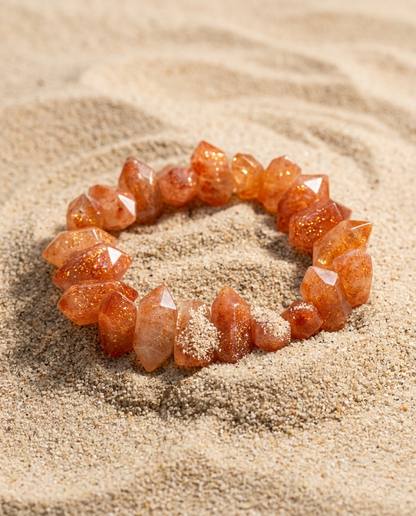 ⁠Macro detail of zero-metal chunky sunstone point bracelet displaying vivid aventurescence on zen sand, high-end healing mineral jewelry by STILLMANTLE⁠