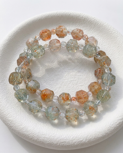 Stack of two faceted Tanzanian sunstone crystal bracelets with clear quartz architectural pauses, resting in a  bowl, mindful earth aesthetic jewelry by STILLMANTLE⁠