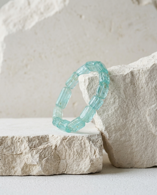 Natural blue aquamarine barrel bead bracelet leaning against rough white stone, zero-metal organic minimalist jewelry for grounding energy by STILLMANTLE⁠
