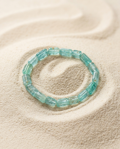 Zero-metal aquamarine crystal bracelet placed on raked zen garden sand, soothing energy stones and mindful quiet luxury accessory by STILLMANTLE⁠