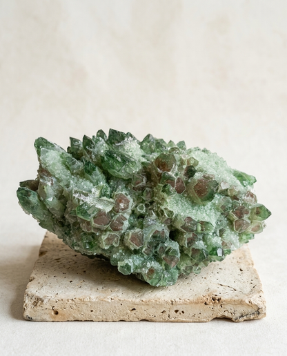 Raw green chlorite phantom quartz cluster with druzy frost on a stepped stone pedestal, museum-grade statement crystal decor, wabi-sabi interior styling by STILLMANTLE⁠