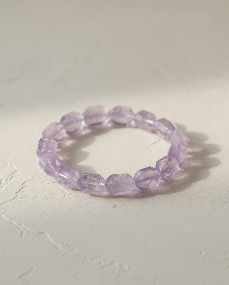 ⁠Custom faceted pale lavender Vera Cruz amethyst crystal bracelet on minimalist textured stone in natural sunlight, ethereal mindful quiet luxury jewelry by STILLMANTLE⁠