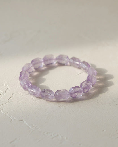 ⁠Custom faceted pale lavender Vera Cruz amethyst crystal bracelet on minimalist textured stone in natural sunlight, ethereal mindful quiet luxury jewelry by STILLMANTLE⁠