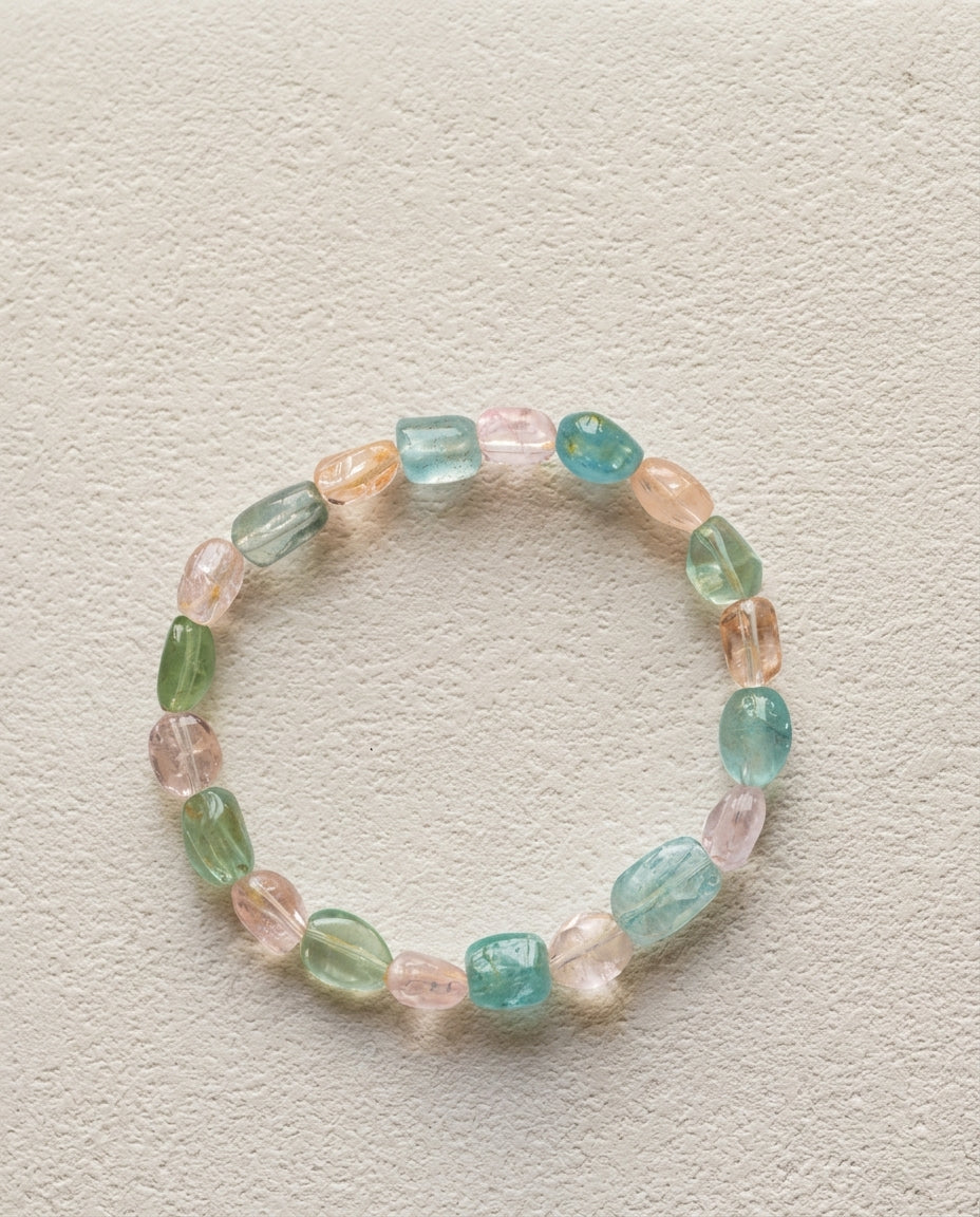⁠Macro close-up of a natural mixed beryl bracelet showing high transparency pink, blue, and green organic tumbled crystals, unheated luxury gemstone bracelet.⁠