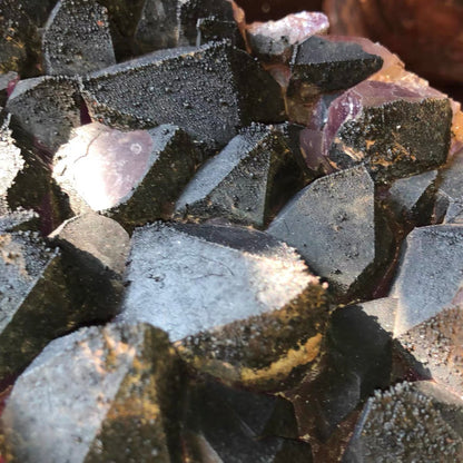 Macro close-up of natural black hematite crystallization overgrowing amethyst quartz points, rare geological mineral specimen texture.⁠