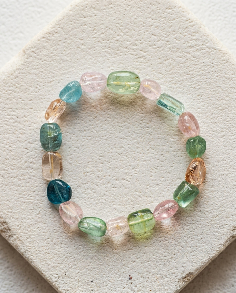 ⁠Natural pastel mixed beryl gemstone bracelet styled with a wabi-sabi crackled ceramic bowl and dried oats on textured stone, luxury aesthetic jewelry.⁠