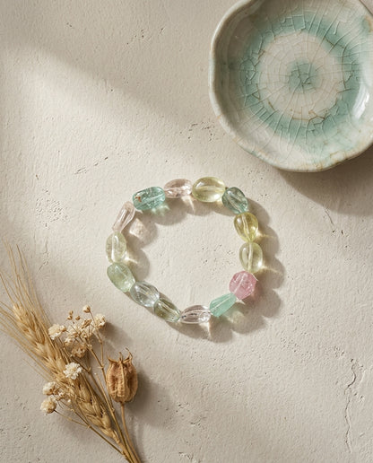 ⁠Natural pastel mixed beryl gemstone bracelet with morganite and aquamarine, styled with a crackle glaze celadon dish and dried wheat on a textured surface, wabi-sabi luxury jewelry aesthetic.⁠