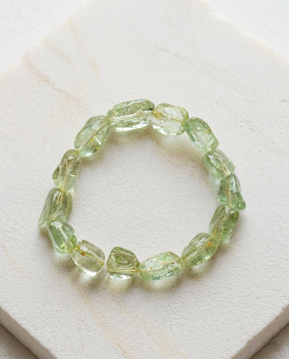 Natural Green Beryl gemstone bracelet styled with a handmade ceramic vase and dried branch for wabi-sabi aesthetic, minimalist fine mineral jewelry photography.