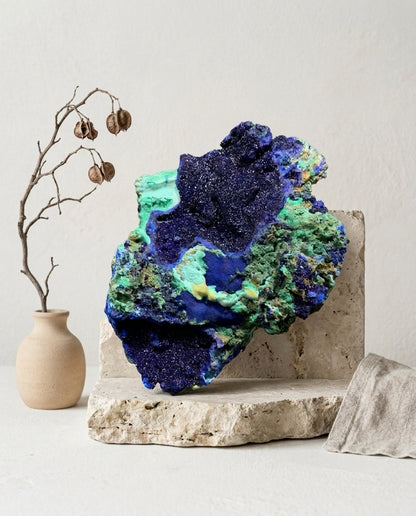 Large raw azurite crystal specimen with green malachite on travertine display. Luxury natural stone decor for organic modern living room.⁠